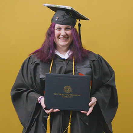 Amber Bownan, an associate in liberal arts and bachelor's in general studies graduate from SNHU wearing her cap and gown in front of a yellow background.