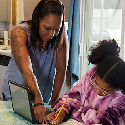 Latisha Aguilar '21, who earned a bachelor’s degree in psychology with a concentration in child and adolescent development, helping her daughter with homework.