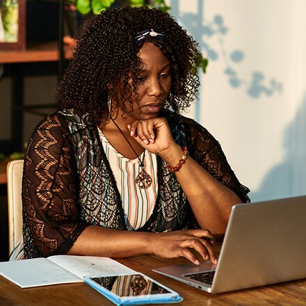 A woman working on her online graduate certificate courses from her laptop.