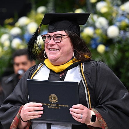 An SNHU graduate at Commencement earning their degree.