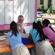 An SNHU student in Belize tutoring three local students.