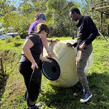Three SNHU students in Costa Rica collaborating with a local school to build a community garden.