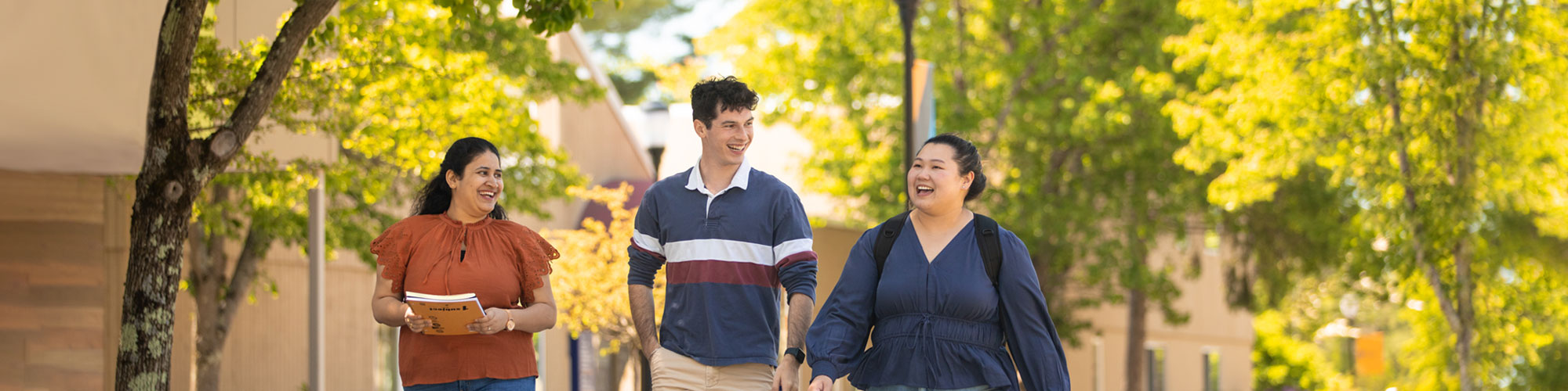 A diverse group of students walking through campus together