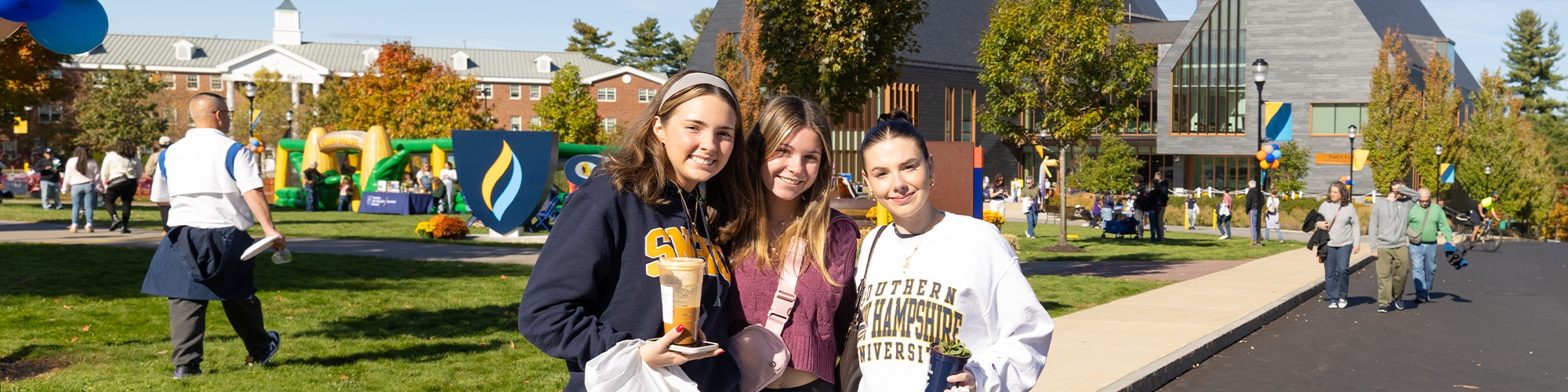 Three SNHU students on campus for a homecoming celebration.