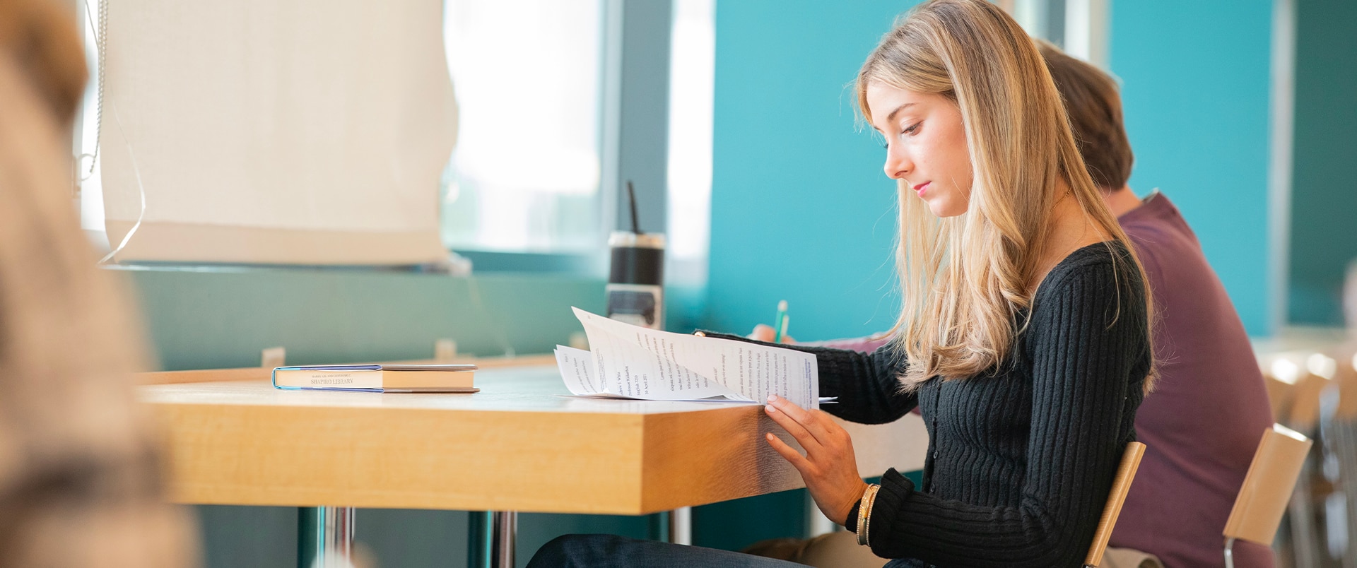 A girl sitting and writing on a paper.