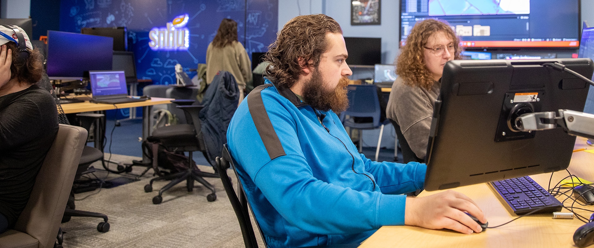 A group of students working on computers in a SNHU lab.
