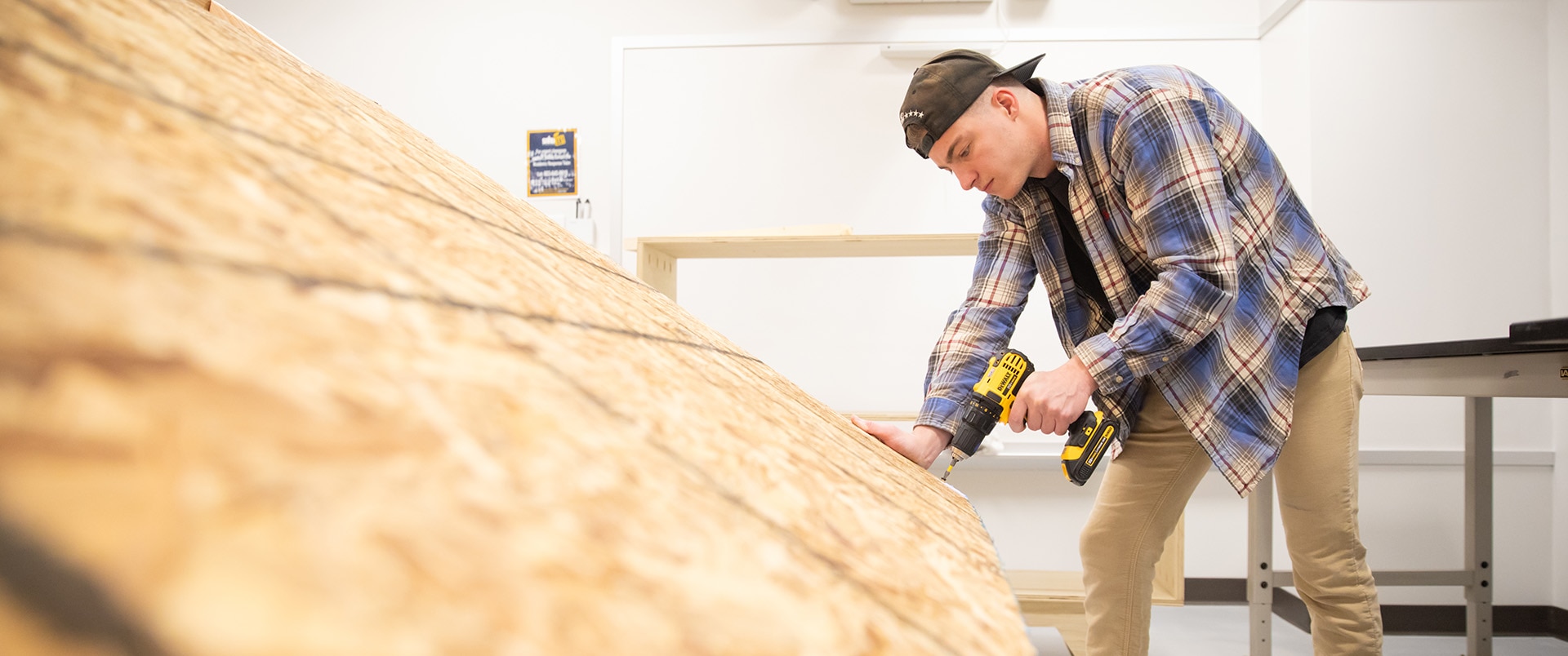 Image of a student working with a battery operated drill machine.
