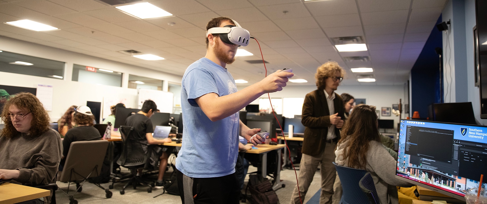 A student testing a gaming program wearing a VR headset.