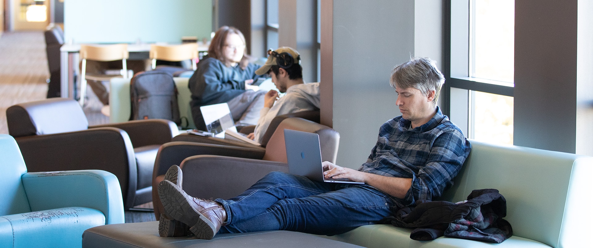 A group of individuals working on their laptops in a lounge area.