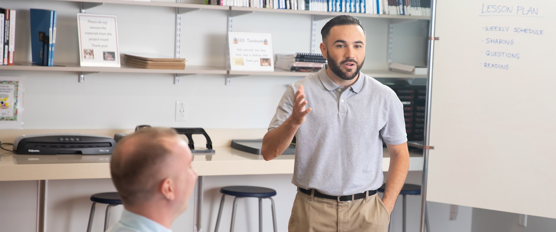 An instructor presenting a lesson plan by using a whiteboard in front of a classroom.