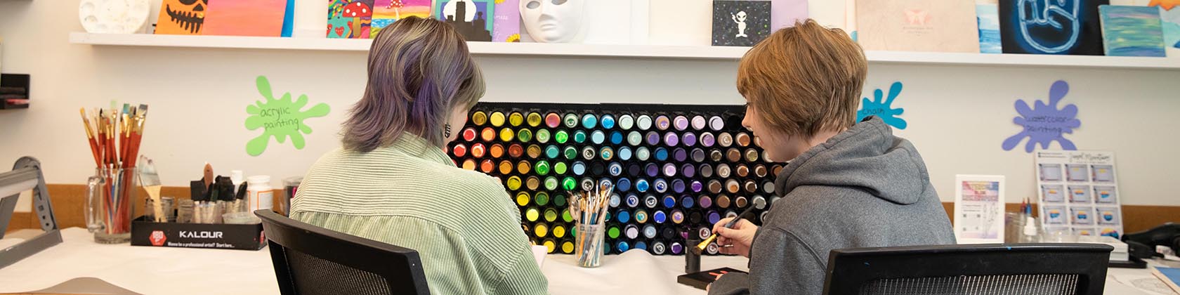 Two students painting in the SNHU Makerspace