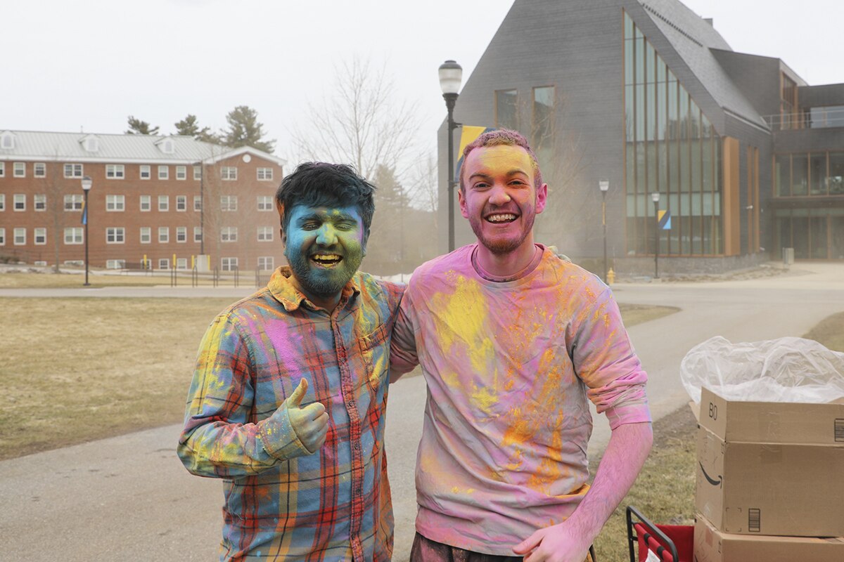 Domenick Donati and Prasiddha Pokhrel, SNHU graduates, at SNHU's Holi celebration covered in multi-colored powders.