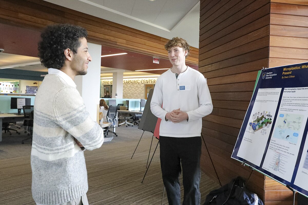 Two students engaging in conversation at SNHU's Undergraduate Research Day.
