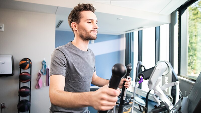 A student using the fitness center in the Lincoln apartment.